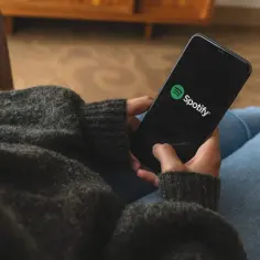 Osoba trzymająca telefon z otwartą aplikacją Spotify.